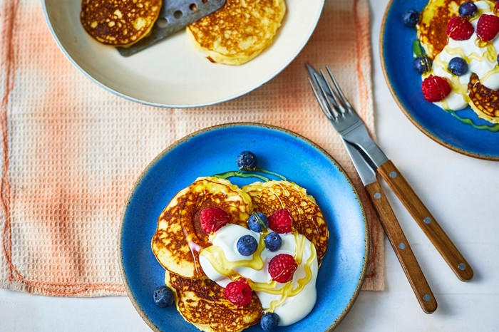 A blue plate with a stack of coconut flour pancakes on top of it