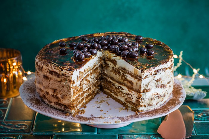 Easy fridge cake with coffee on a cake stand with a wedge taken out