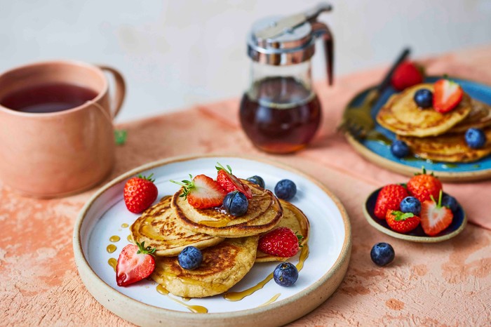 A plate of cottage cheese pancakes with fresh fruit on top