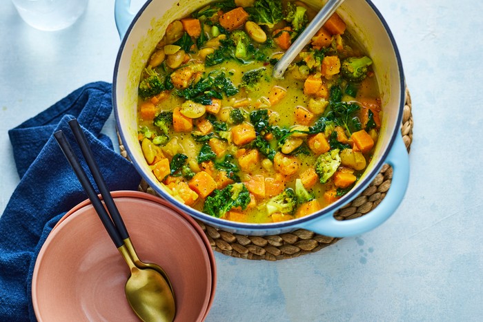 A hearty one-pot in a yellow broth with vegetables and spinach