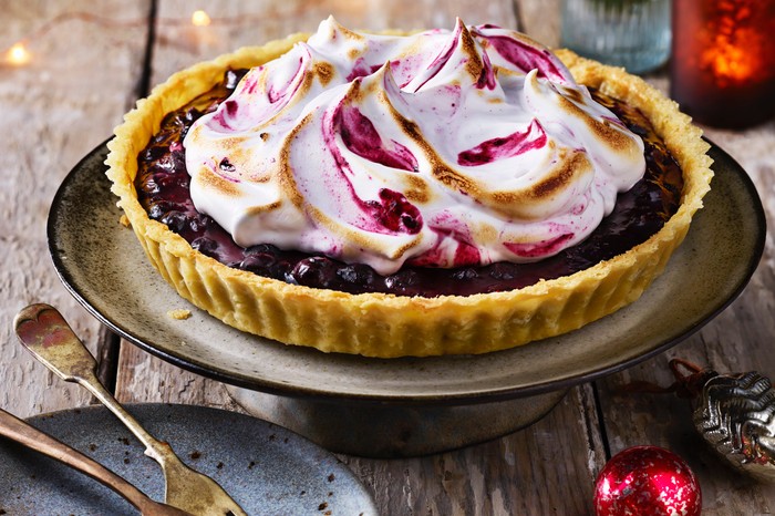 A beautiful blueberry tart with a crown of scorched meringue on top of it