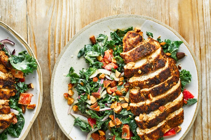 Cumin-Crusted Chicken with Kale Salad on two Plates