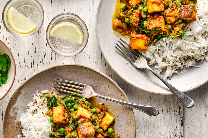 two plates of paneer curry with rice