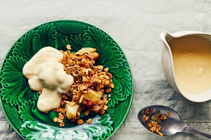 A green bowl with apple crumble in it