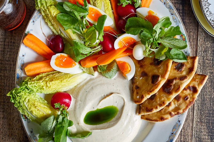 Smoked cod's roe dip on a plate with vegetables, boiled eggs and flatbreads