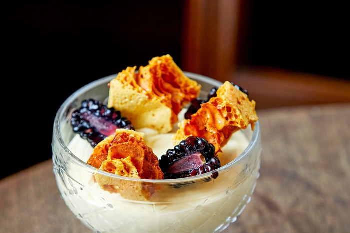 A small glass dish of white chocolate mousse with honeycomb on top