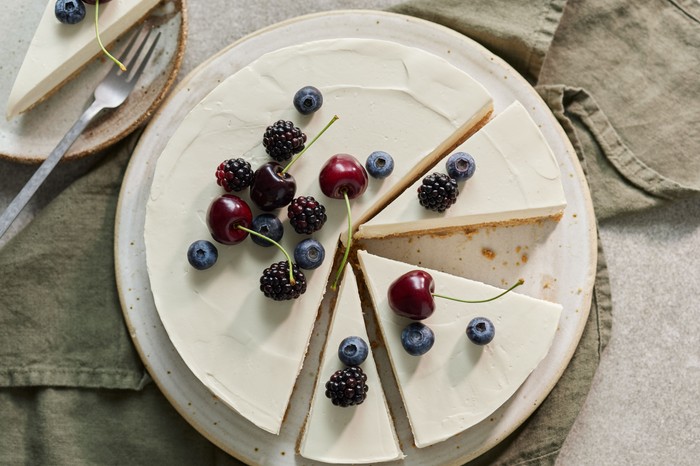 Vegan vanilla cheesecake topped with berries and cherries