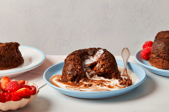 Chocolate molten cake with cream poured over on a plate