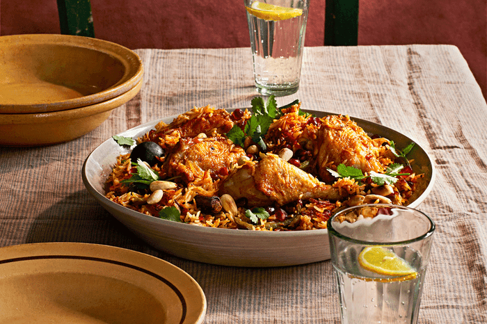 Bowl of Omani chicken one-pot rice on a table garnished with fresh herbs